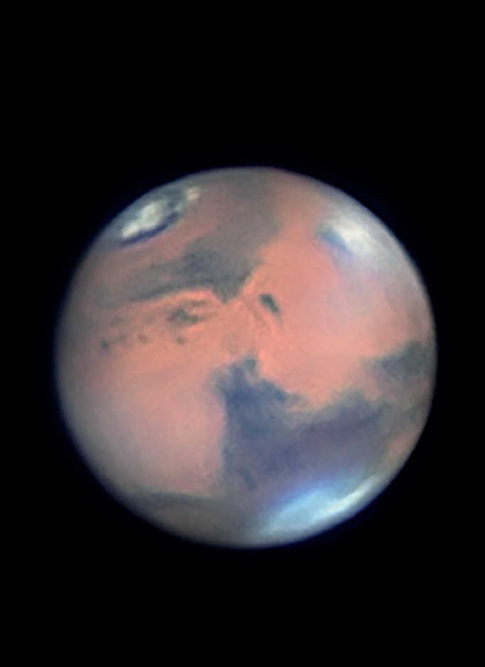 Zdjęcie Marsa. Wyraźnie widać chmury w rejonie dużego wulkanu tarczowego Elysium Mons. Uwagę przykuwa również mocno wytopiona północna czapa polarna. Mario Weigand